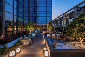 An outdoor lounge area with seating and a pathway leading to a building entrance. - UrCove by Hyatt Shenzhen Bay Nanyou (Shenzhen)