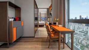 A modern hotel room with a dining area, a view of the cityscape, and a kitchenette. - UrCove by Hyatt Shenzhen Bay Nanyou (Shenzhen)