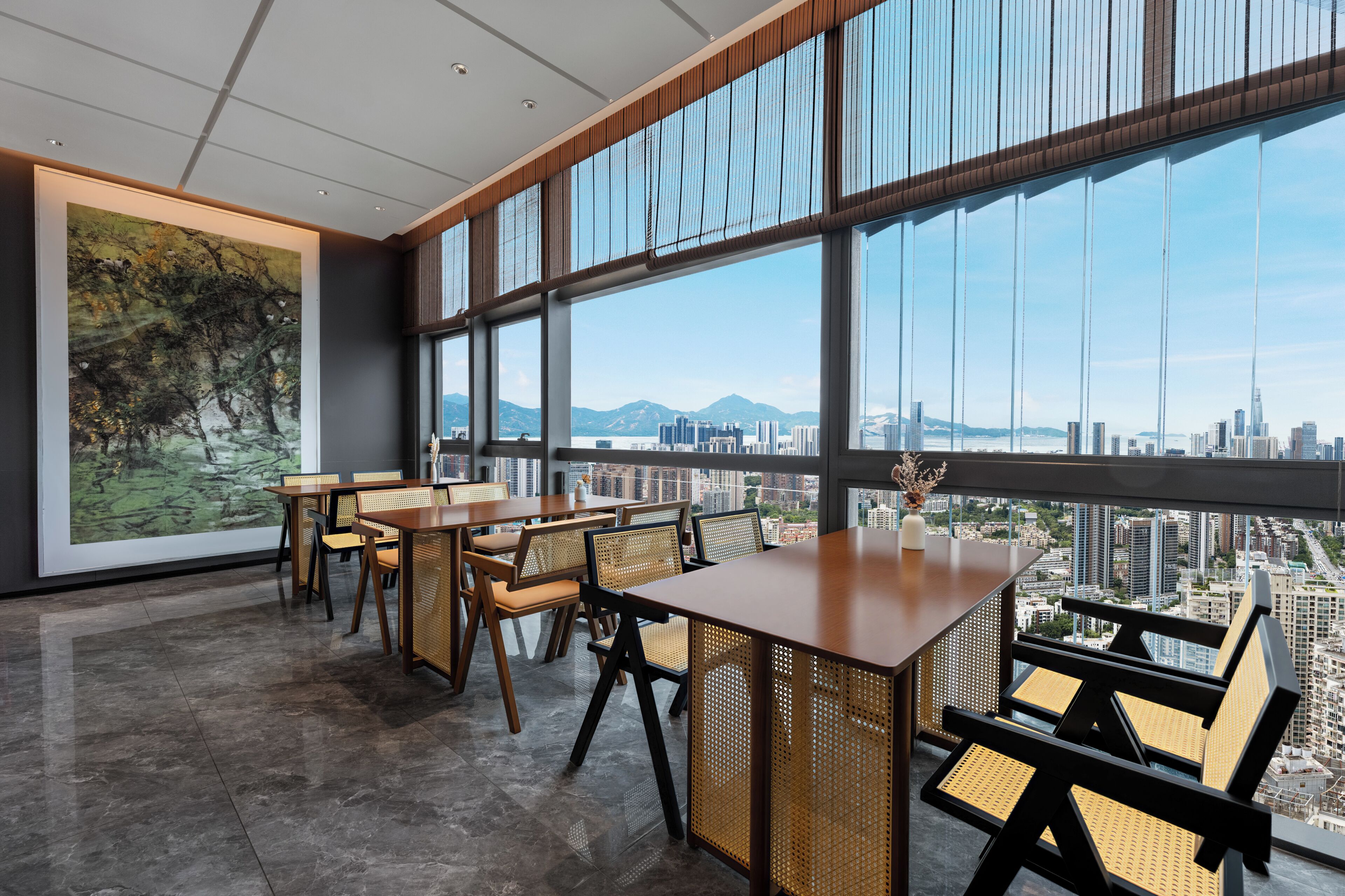 Un interior moderno con amplios ventanales, vistas a la ciudad y un comedor con mobiliario de madera.