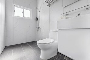 Standaard vierpersoonskamer | Badkamer | Een douche, een haardroger, pantoffels, handdoeken