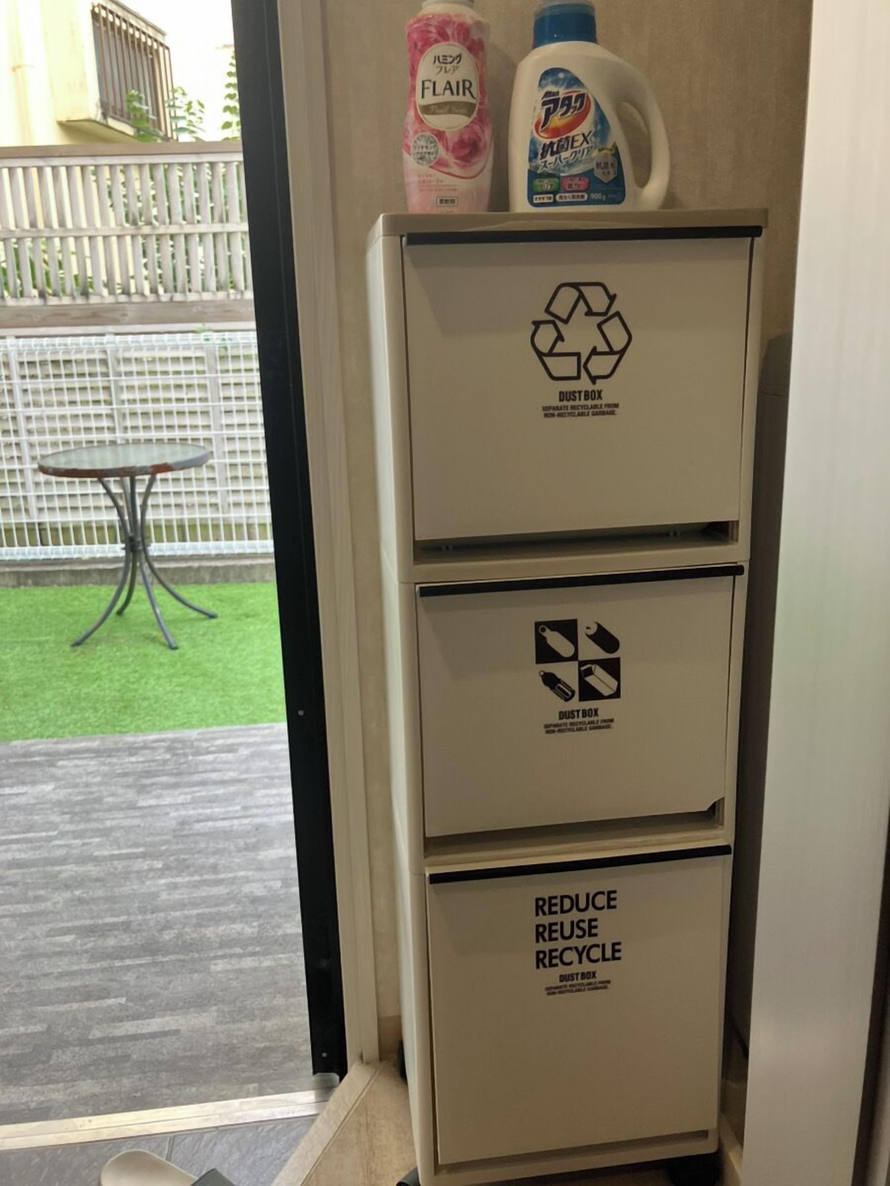 A white cabinet with recycling symbols and text, placed near a door.