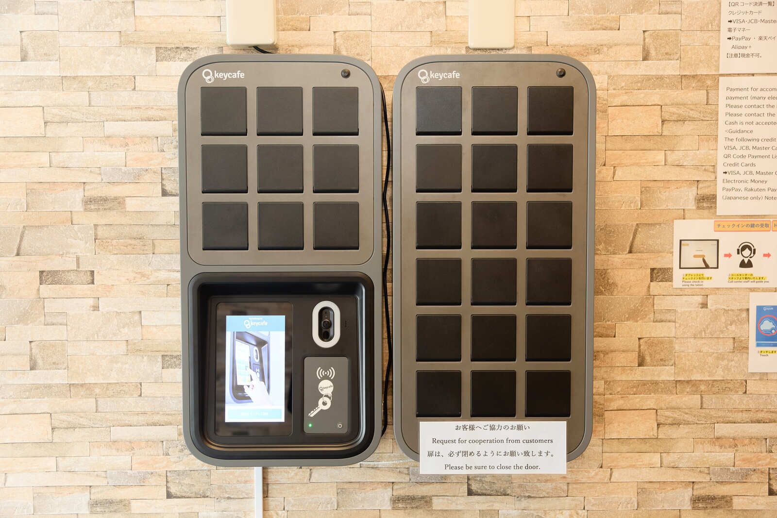 Two keycard readers mounted on a stone wall, with a digital display and a keypad below one of them.