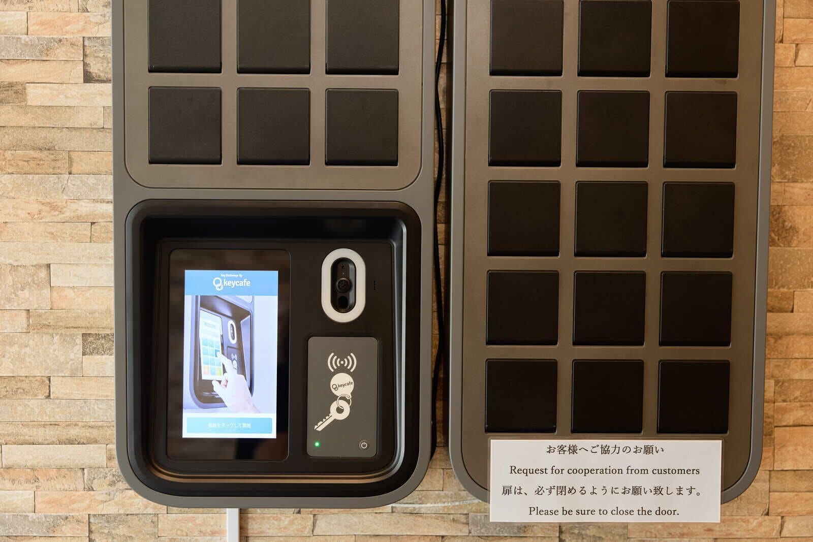 A digital key card reader with a screen displaying a QR code, a key symbol, and a Wi-Fi signal icon.