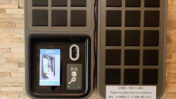 A digital key card reader with a screen displaying a QR code, a key symbol, and a Wi-Fi signal icon.