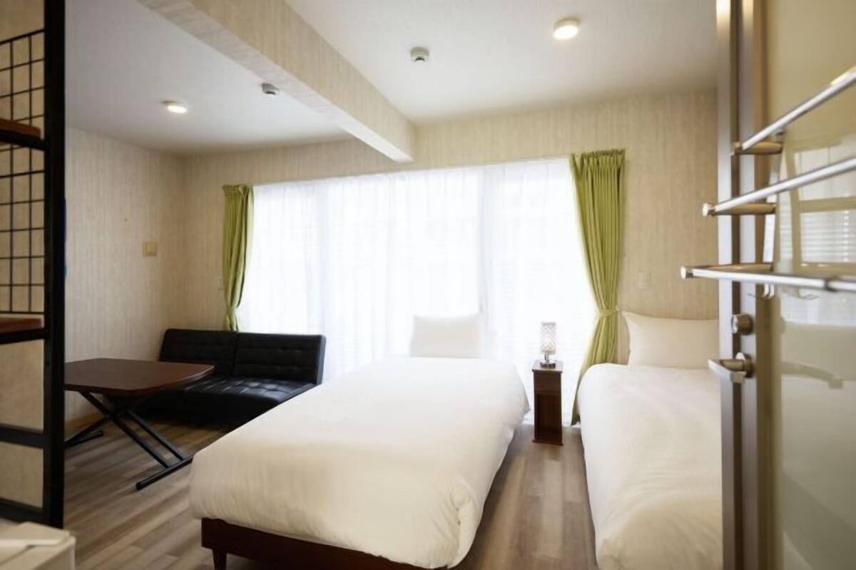 A hotel room with a bed, a desk, and a chair.