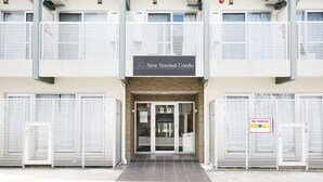 A building entrance with a sign reading 'New Normal Condo.' - New Normal Condo in KENCHOMINAMIGUCHI (Naha)