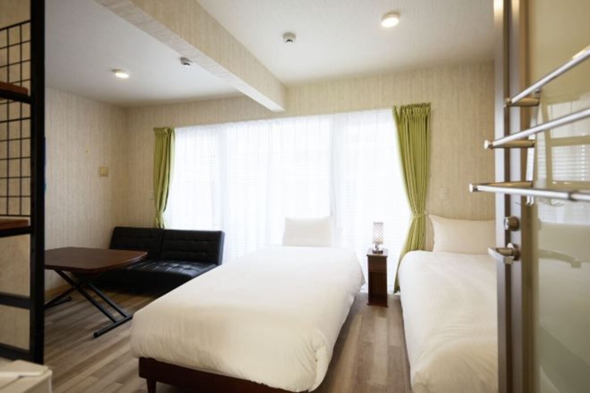 A hotel room with a bed, a desk, and a chair.