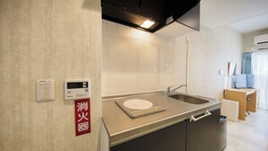 A modern kitchen with a built-in oven, a sink, and a digital scale. - New Normal Condo in KENCHOMINAMIGUCHI (Naha)