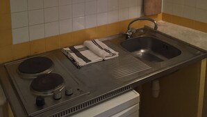 Eine Küche mit weißen Schränken, einer Edelstahlspüle und einem eingebauten Herd.