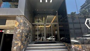 The entrance to The Rose on 117, featuring a modern facade with stone accents and a clear glass entrance. - Urban Elephant The Rose (Cape Town)