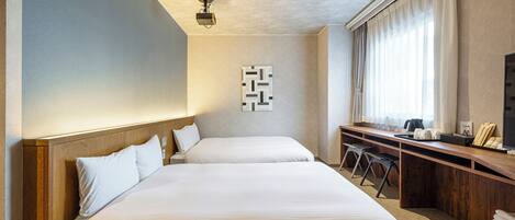 A hotel room with two beds, a desk, a chair, a TV, and a large window with curtains.