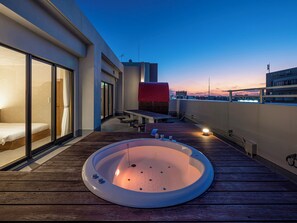 A rooftop terrace with a hot tub, a bed, and a dining area. - LACER OKINAWA NAHA MIEBASHI (Naha)