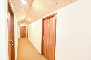 Un pasillo con puertas de madera y alfombra color beige.