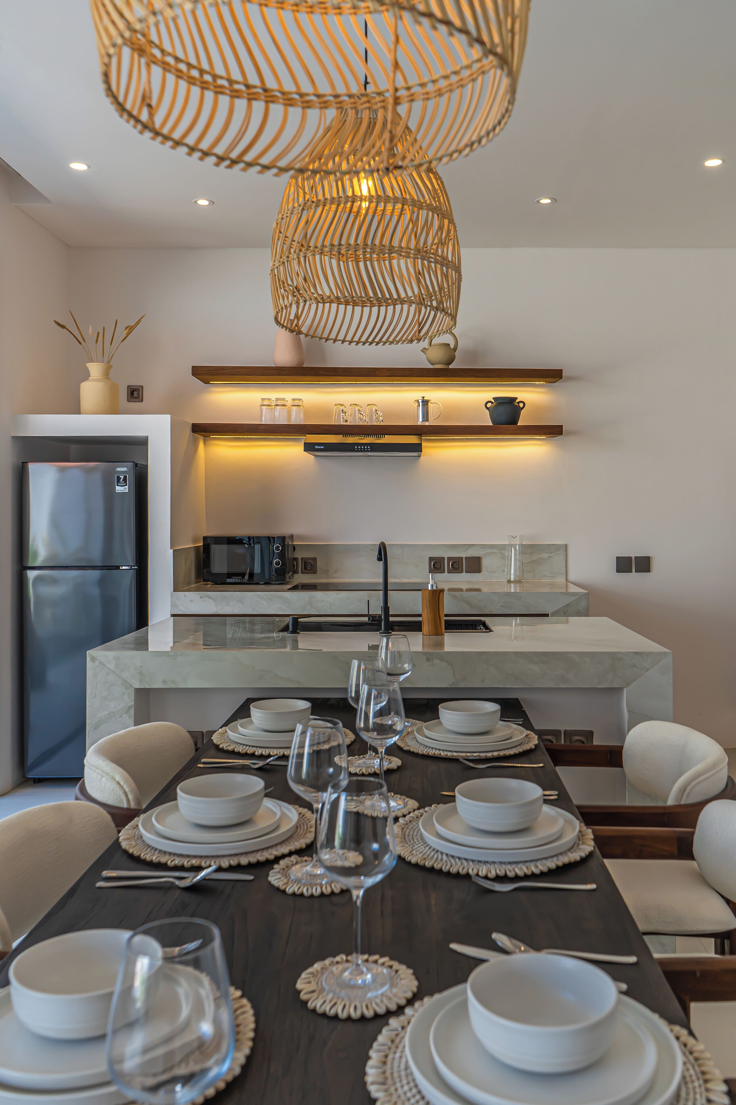 A modern kitchen with a central island, built-in appliances, and a dining area set for six.