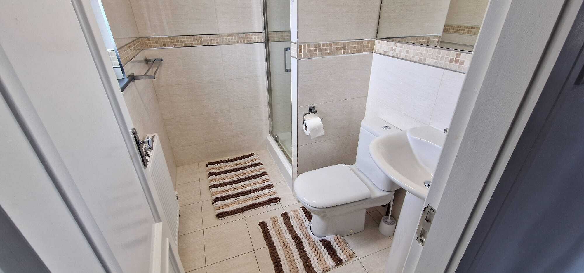 A bathroom with a toilet, sink, and shower area.