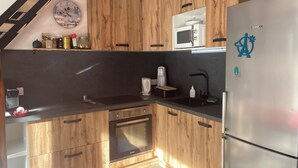 Cozinha com armários de madeira, geladeira Bosch, micro-ondas e cafeteira.