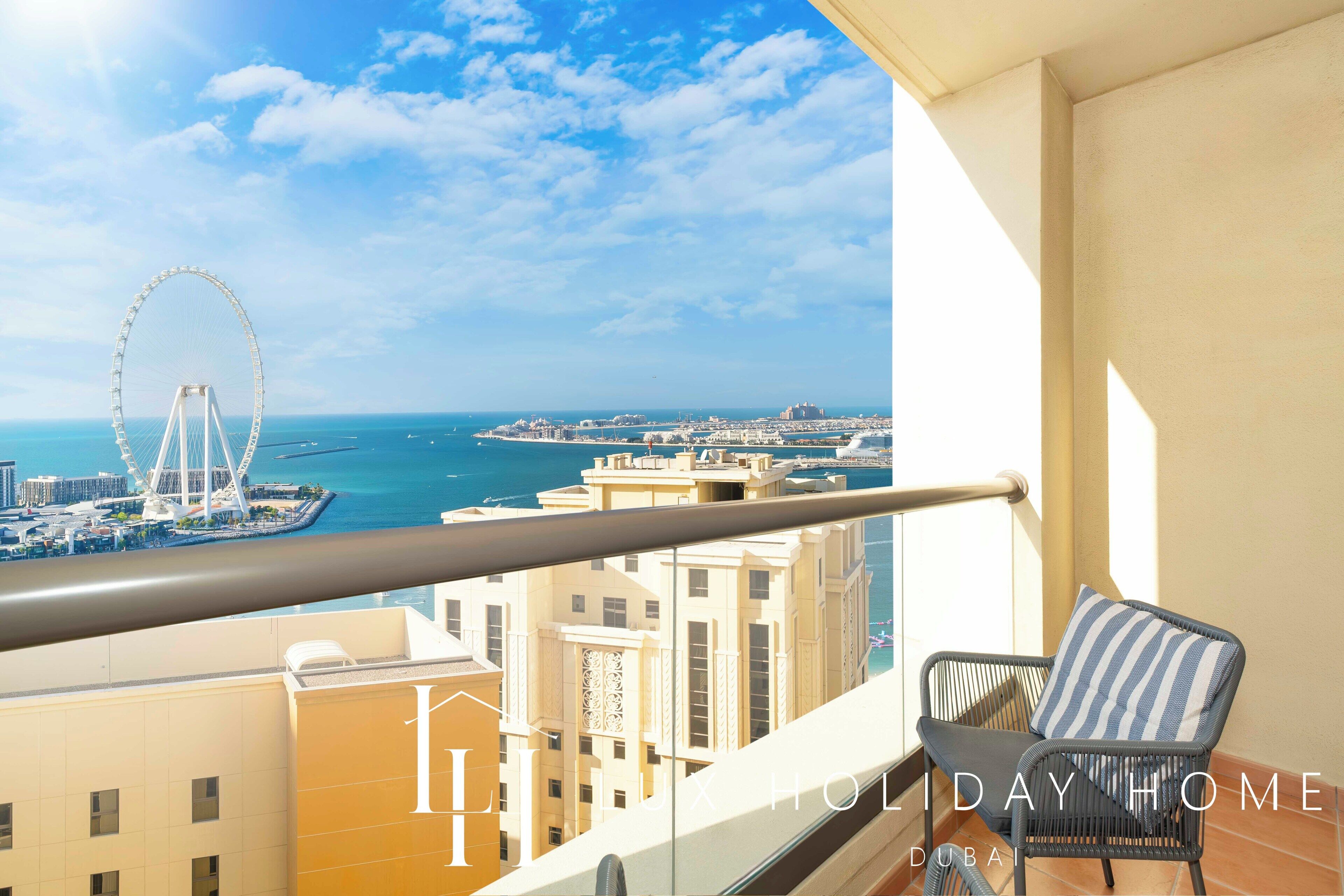 Ein Balkon mit Blick auf ein Riesenrad und das Meer.