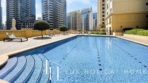 A swimming pool with a view of high-rise buildings in the background. - LUX  The Dubai Eye Sea View Suite (Dubai)