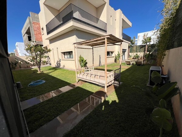A modern two-story house with a covered patio and a well-maintained lawn. - VILLA RANA (Marrakech)