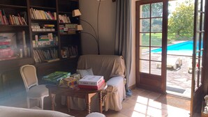 Een gezellige woonkamer met een boekenplank, een fauteuil en een tafel met gezelschapsspellen.