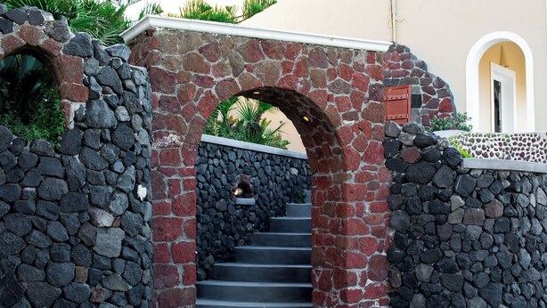 A stone staircase leading to a door with a red mailbox. - Ostria, Pithos Apartments (Thira - Santorini)