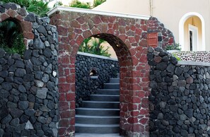 A stone staircase leading to a door with a red mailbox. - Ostria, Pithos Apartments (Thira - Santorini)
