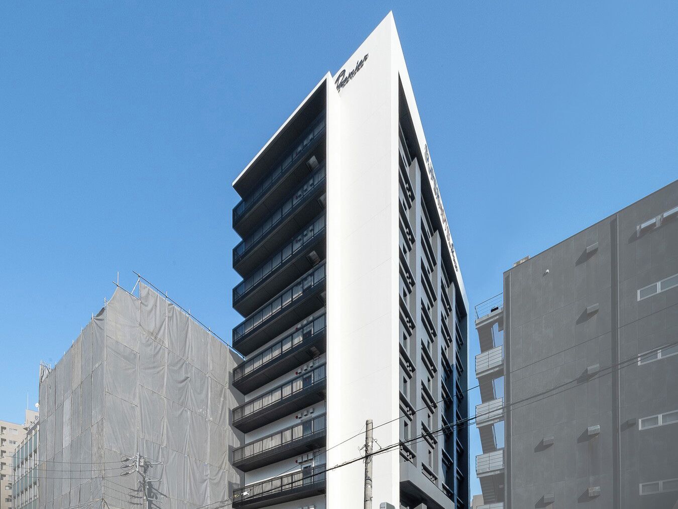 Een modern gebouw met meerdere balkons en een opvallend bord.