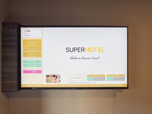 Een digitaal scherm met de wifi-instellingen en faciliteitenlijst van een hotelkamer.