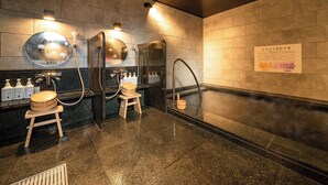 Ein modernes Badezimmer mit zwei Waschbecken, einem großen Spiegel und einem hölzernen Hocker.