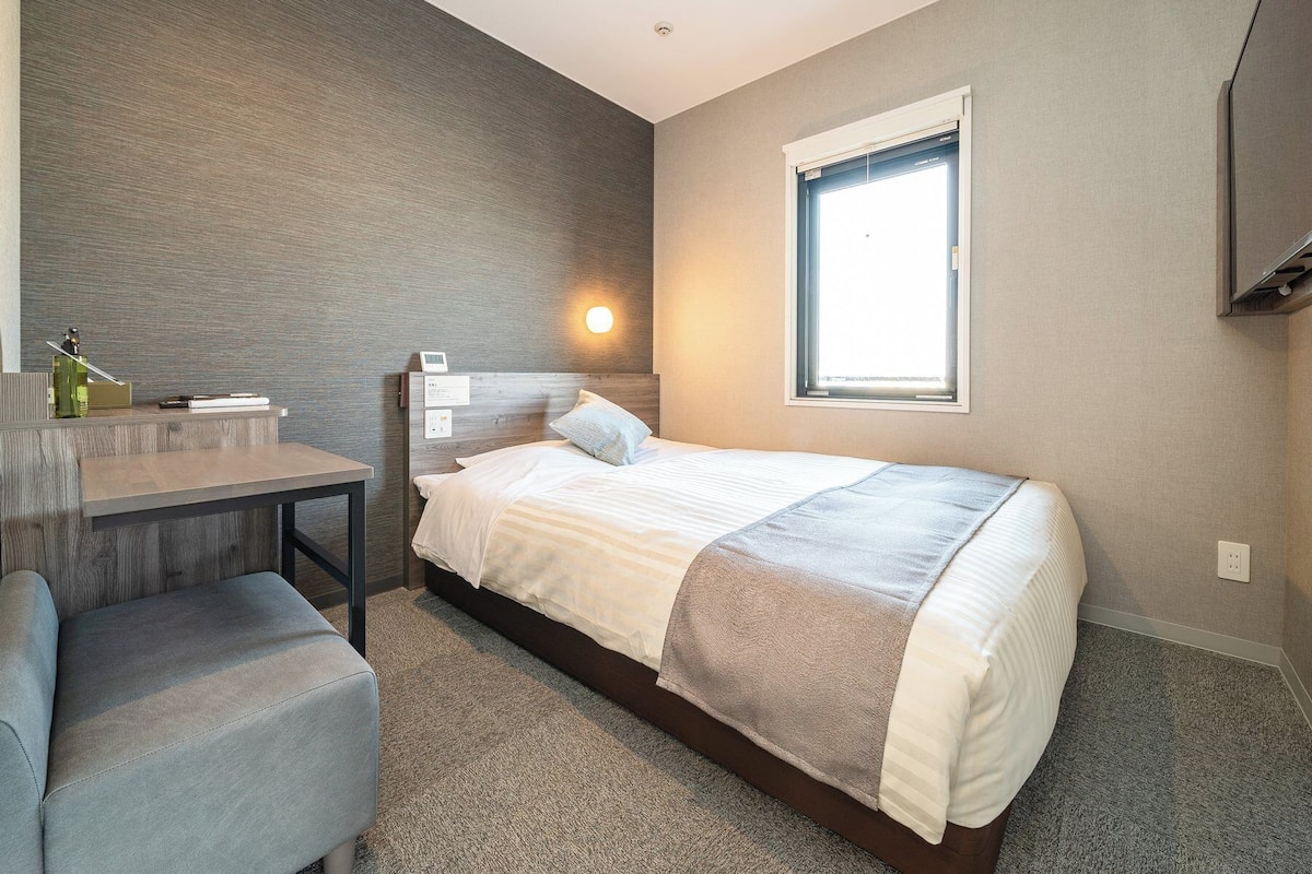 Une chambre à coucher moderne avec un lit, un bureau et une chaise.