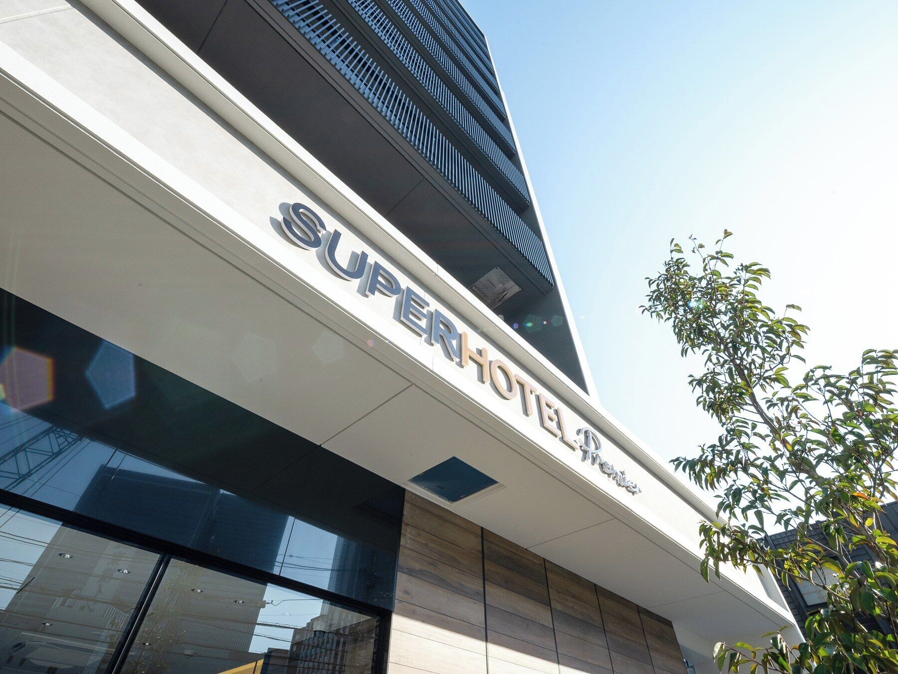 Un moderno edificio de hotel con un llamativo letrero de 'Super Hotel'.