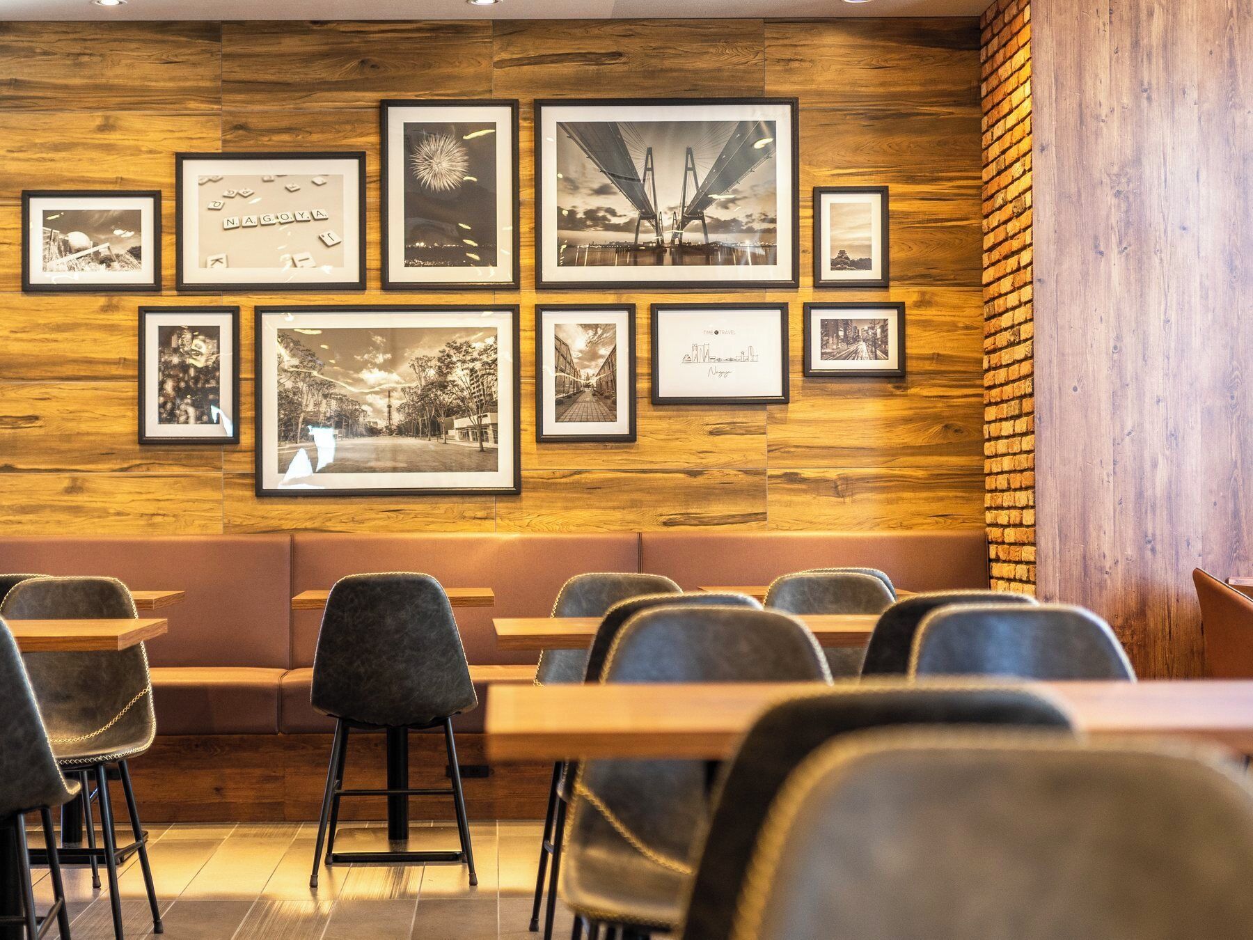 A restaurant interior with wooden panel walls, multiple framed photographs, and a mix of booth and table seating.