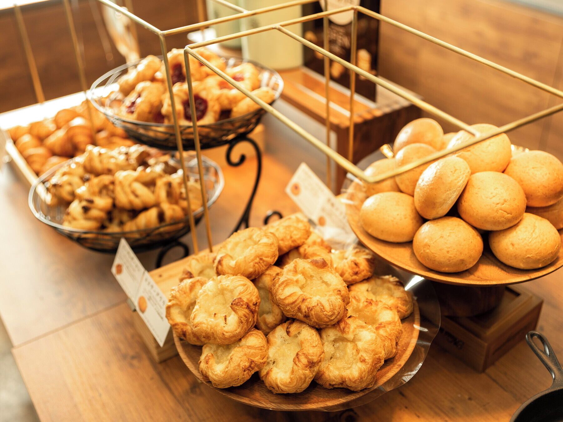 A buffet table with various baked goods including pastries and bread.