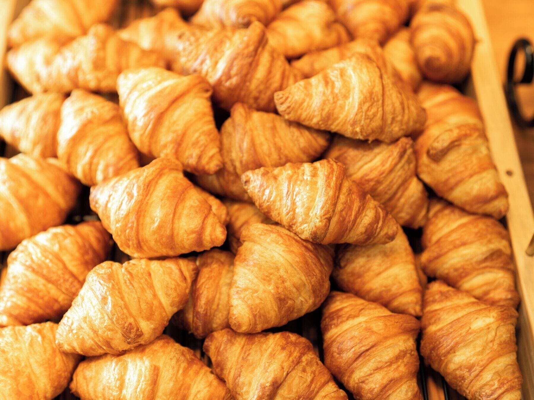 Een doos vol goudbruine croissants.
