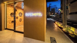 The exterior of a hotel with a neon sign reading "SUPERHOTEL" and a tiled entrance. - SUPER HOTEL Nagoya Natural Hot Spring Shinkansenguchi (Nagoya)