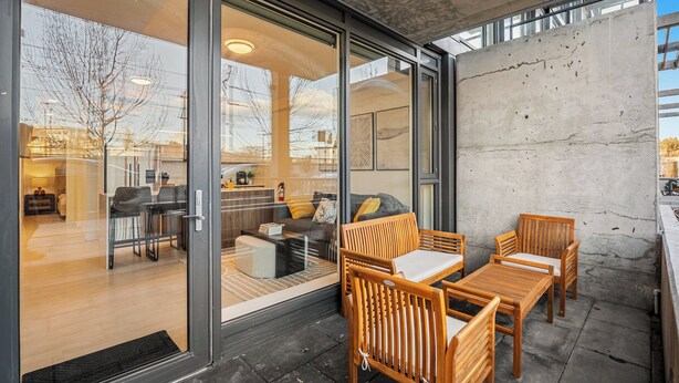 A modern interior with a glass door marked "321," wooden furniture, and a concrete wall. - Modern Ground-Level Suite UG Parking, AC, C-Train (Calgary)