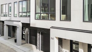 A modern multi-story residential building with large windows and a clean, minimalist design. - Western Chic Retreat 3BR w/ 3 Ensuites, Prkg, AC (Calgary)