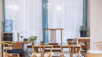 Una habitación con una mesa de comedor, sillas, un dispensador de agua y una planta en maceta.