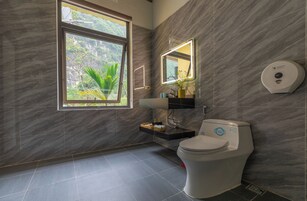 Un baño moderno con inodoro, lavabo y espejo.