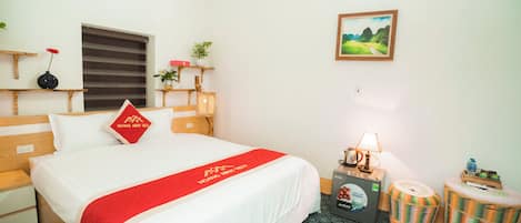 A hotel room with a bed, bedside tables, a lamp, a picture on the wall, and a window with a view.