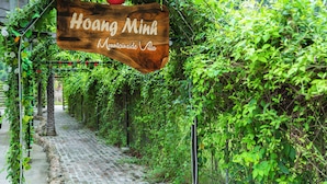 Un letrero de madera con el texto 'Hoang Minh Mountainside Villa'.