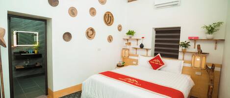 Habitación de hotel con cama, espejo, baño y pared decorada con motivos circulares.