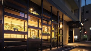 Un edificio con varios balcones, cada uno con plantas y un reloj.