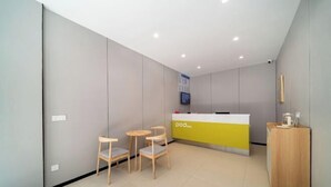 Una zona reception con un banco, sedie e un tavolino.