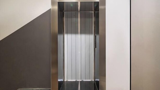 Un ascensore moderno con finiture metalliche e un design essenziale ed elegante.