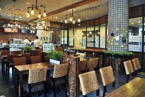 A restaurant with wooden furniture, hanging lights, and a large pillar with notes. - Yingkou International Hotel (Yingkou)