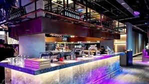 A modern bar area with a marble countertop, shelves with bottles, and a variety of bar tools. - Yingkou International Hotel (Yingkou)