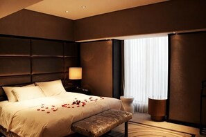 A modern hotel room with a large bed, a bedside table, a lamp, and a window with curtains. - Yingkou International Hotel (Yingkou)