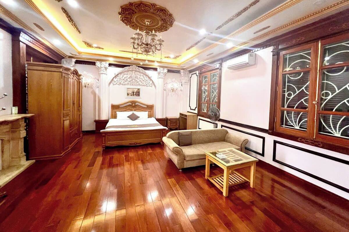 Ein Zimmer mit Holzboden, einem Bett, einer Couch und einem Tisch.
