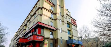 Un edificio de varios pisos con una planta baja comercial, que cuenta con un restaurante y una tienda.